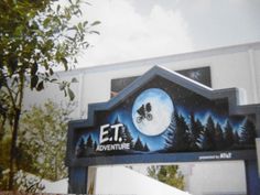 an entrance sign for the e t adventure park with trees and sky in the background