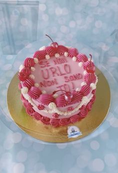 a pink cake with white frosting on a gold plate