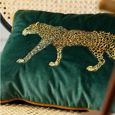 a green pillow with a gold leopard on it