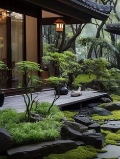 a japanese garden with rocks, grass and trees