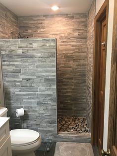 a bathroom with a walk in shower next to a toilet