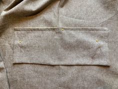 a piece of cloth with yellow stitching on it and some other things in the pocket