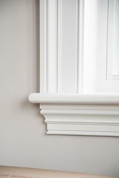 a cat sitting on the edge of a window sill