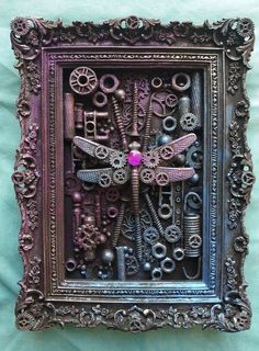 an intricately decorated metal frame with dragonflys and gears