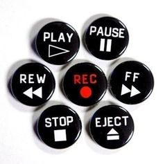 four black buttons with white letters and red arrow pointing to play pause, stop, reverse