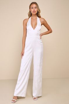 All eyes will be on you (with good reason!) when you're looking so sophisticated in the Lulus Elegant Aspect Ivory Floral Jacquard Halter Wide-Leg Jumpsuit! Lightweight woven satin boasts a chic floral jacquard design as it shapes a tying halter neckline and a bodice with seamed cups and a set-in waist. Wide legs finish at ankle-length hems. Hidden zipper/clasp and elastic at back. Fit: This garment fits true to size. Length: Floor length. Size medium measures 58" from top to bottom. Inseam: 32. Glamorous Spring Wedding Jumpsuit Or Romper, White Jumpsuits And Rompers For Spring Wedding, Fitted Cream Jumpsuits And Rompers For Party, Elegant White Jumpsuit For Formal Occasions, Elegant Cream Jumpsuit For Party, Elegant Cream Jumpsuits And Rompers For Party, Feminine Fitted Jumpsuit For Formal Occasions, Feminine Fitted Jumpsuits And Rompers For Formal Occasions, Feminine White Jumpsuits And Rompers For Party