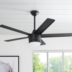 a black ceiling fan in a white room