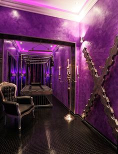 a room with purple walls and chairs in it