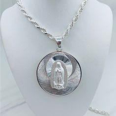 925 Sterling Silver Medallion And Rope Necklace Double Sided With Our Lady Of Guadalupe And Sacred Heart Of Jesus Pendant 46mm In Diameter Rope Necklace 26” Long And 5mm Wide Dije En Plata De La Virgen De Guadalupe Doble Cara Con La Virgen Y Sagrado Corazn Mide 46 Milmetros Plata 925 Cadena De Lazo Mide 26 Pulgadas De Larga Y 5 Milmetros De Ancho Sku 5143 P Sku 53153 N Sterling Silver Medallion With Polished Finish, Sterling Silver Medallion Jewelry With Polished Finish, Polished Sterling Silver Medallion Jewelry, Silver Sterling Silver Large Pendant Jewelry, Custom Round Sterling Silver Necklace With Polished Finish, Silver Necklaces With Shiny Finish For Gifts, Silver Necklace With Shiny Finish For Gift, Silver Medallion Jewelry With Sterling Silver Clasp, Silver Pendant Necklace With Shiny Finish