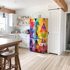 a brightly colored refrigerator in a white kitchen