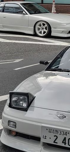 two white cars parked next to each other on a street