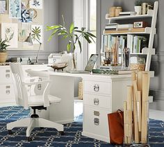 a home office with blue walls and white furniture, including a desk in the center