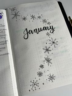 an open planner with snowflakes and the word january written in black on it