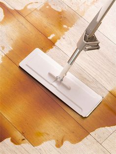 a mop is laying on the floor next to a wooden floor that has been stained brown