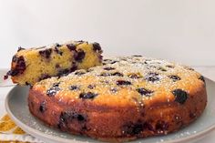 a blueberry cake on a plate with one slice cut out