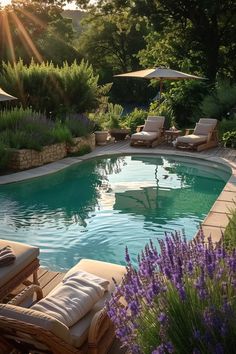 an outdoor swimming pool with lounge chairs and umbrellas around it, surrounded by greenery