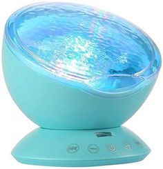 a blue speaker sitting on top of a white table next to a light green base