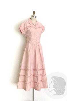 vintage dress  Era: 1940's 1950's Label: none Material: cotton and embroidery  Closure: front buttons, side metal zipper  Colour: pink  Details: unique gathered sleeve details, small ruffle and embroidered accents along the bodice and skirt Fits like: small Bust: 34" Waist: 26" Hips: free Length: 47" Condition: One small, faint spot near the hem and two pin sized spots. A couple pin sized holes on the skirt. Presents beautifully and priced accordingly.  Washed and ready to wear.  shop policy  * 40's Fashion, Ruby Mae, Dress Pastel, Dresses 40s, Vintage Dresses 50s, 1940s Dresses, Rose Vintage, 50s Vintage, Ruffle Shirt