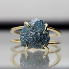 a close up of a ring with a blue stone on the middle and two gold rings around it