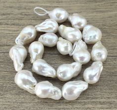 a strand of white pearls on a wooden table