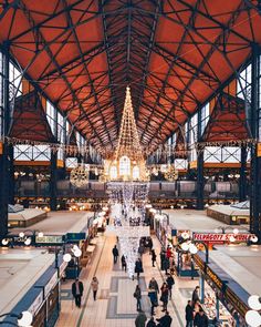 people are walking around in an indoor shopping mall with chandeliers hanging from the ceiling