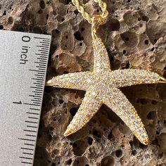 Get noticed with this sparkling 18K Gold Filled Large Star Fish Pendant. Each cubic zirconia is individually mounted to create an organic textured look with incredible shine. Each tip of the Star Fish has a polished finish further accenting the design. Includes 18K Gold Filled 3mm width, extra long 24 inch length Chain. 18K Gold Filled Star Fish Pendant Cubic Zirconia individually mounted Incredible shine and sparkle Polished tips accent the design Includes 18K Gold Filled 3mm width, extra long Star-shaped Yellow Gold Cubic Zirconia Jewelry, Gold Star-shaped Jewelry With Sparkling Stones, Gold Star Jewelry With Sparkling Stones, Yellow Gold Star-shaped Cubic Zirconia Jewelry, Gold Star-shaped Sparkling Jewelry, Gold Sparkling Star Jewelry, Sparkling Gold Star-shaped Jewelry, Star-shaped Cubic Zirconia Jewelry With Sparkling Stones, Cubic Zirconia Star Jewelry With Sparkling Stones