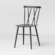 a black wooden chair sitting on top of a white floor