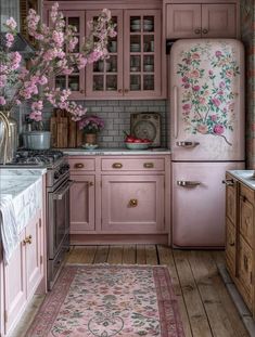 a kitchen with pink cabinets and flowers on the counter top, rug in foreground