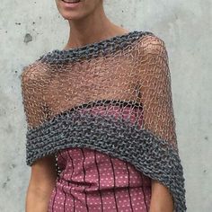 a woman standing in front of a white wall wearing a dress and smiling at the camera