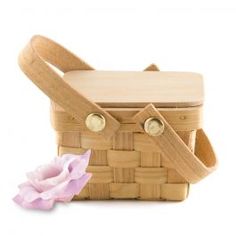 a small wooden basket with a flower on the side