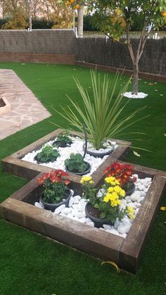 a wooden planter filled with lots of flowers on top of a lush green field