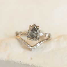 a diamond ring sitting on top of a white surface