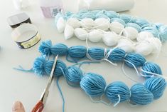 the yarn is being worked on by someone using scissors to cut it up into balls