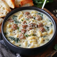 a bowl of pasta soup with meatballs and spinach