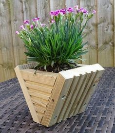 a wooden planter with purple flowers in it