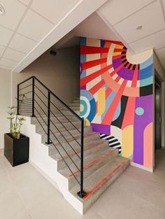 the stairs are painted with different colors and designs on them, along with potted plants