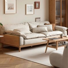 a living room with white couches and wooden tables in it's center area