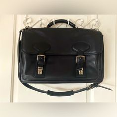 This Buttery Soft Black Coach Messenger Bag Is In Near Perfect Condition. The Only Bit Of Wear Is On A Couple Of The Bottom Corners. On The Inside Center, There Is One Large Padded Zippered Compartment For A Computer That Is 2 1/2 Inches Wide. In Front Of That, Behind The Buckle And Snap Enclosures, There Is An Open Compartment With Three Slip Pockets And Three Pen Pockets. On The Back Side Of The Bag, There Is One Large Open Pocket That Contains Three Slip Pockets And One Zippered Compartment. Measures: Length - 17” Width - 11” Depth 5” Stored In A Smoke-Free Home. Business Tote Bag With Silver-tone Hardware, Business Shoulder Bag With Silver-tone Hardware, Classic Everyday Satchel With Silver-tone Hardware, Office Bag With Silver-tone Hardware And Rectangular Shape, Business Bag With Silver-tone Hardware And Double Handle, Black Timeless Briefcase For Travel, Professional Bag With Silver-tone Hardware And Double Handle, Rectangular Office Bag With Silver-tone Hardware, Classic Black Office Bags