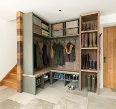 a walk in closet filled with lots of shoes and boots next to a wooden door