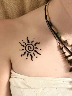 a woman's chest with a tattoo on it that looks like the sun and moon