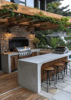 an outdoor kitchen with bar stools and grill