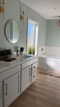 a bathroom with a tub, sink and mirror on the wall next to each other