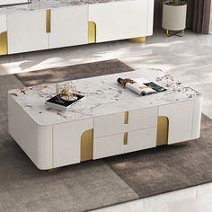 a white coffee table with gold trim around the top and drawers on each side in a living room