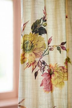 a curtain with flowers painted on it in front of a window