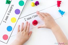 a child's hands on top of a piece of paper with letters and shapes