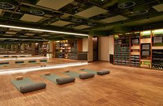 there are many yoga mats on the floor in this room with shelves full of books