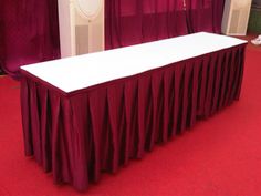 a white table with red drapes on it