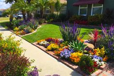 a garden with colorful flowers in front of a house