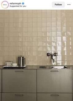 a kitchen with stainless steel cabinets and white tile backsplash, two faucets on each side