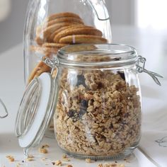 a jar filled with oatmeal sitting on top of a table next to cookies